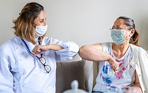 Doctor and patient greeting one another with an elbow bump