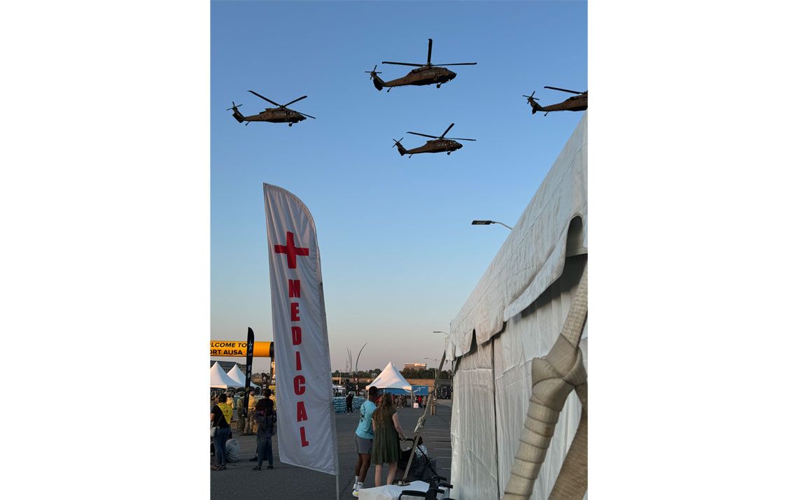 Helicopters flying in the sky above a medical tent