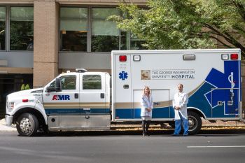 Babak Sarani and Tiffany Coullahan standing in front of an ambulance